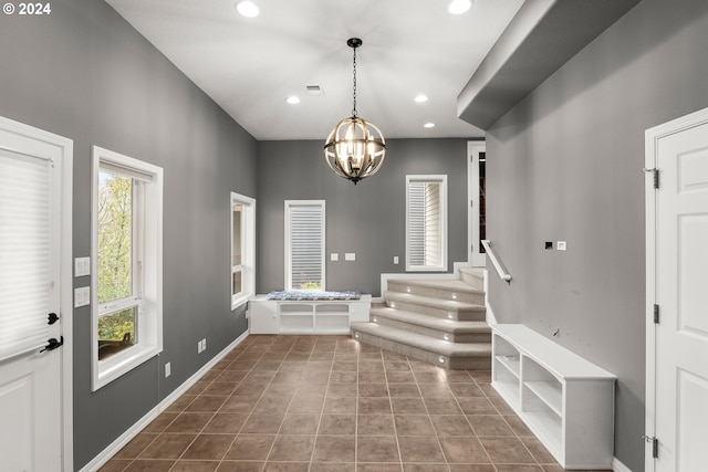 tiled entryway with a notable chandelier