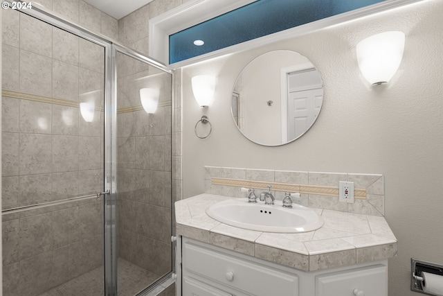 bathroom with vanity and a shower with shower door