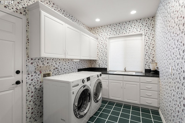 washroom with cabinets, washing machine and dryer, dark tile patterned flooring, and sink