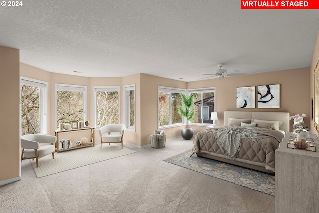 bedroom with carpet flooring, a textured ceiling, multiple windows, and ceiling fan