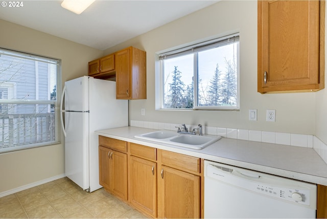 kitchen with a healthy amount of sunlight, sink, and white appliances