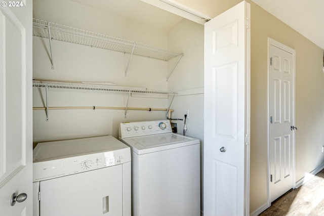 laundry room with wood-type flooring and independent washer and dryer