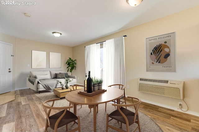 living area featuring hardwood / wood-style flooring and an AC wall unit