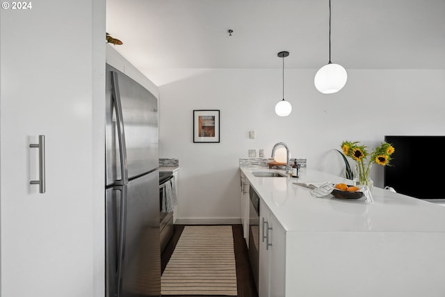 kitchen with sink, pendant lighting, kitchen peninsula, and stainless steel appliances