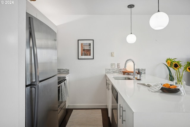 kitchen with decorative light fixtures, stainless steel appliances, sink, dark hardwood / wood-style floors, and kitchen peninsula