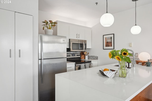 kitchen with decorative light fixtures, decorative backsplash, white cabinets, and stainless steel appliances