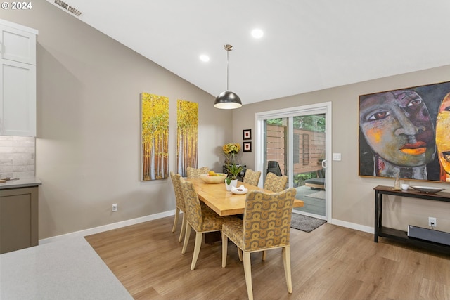 dining area featuring vaulted ceiling and light hardwood / wood-style floors