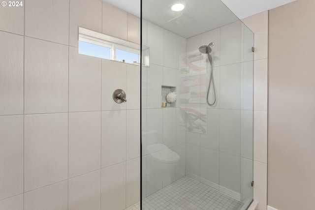 bathroom with toilet and a shower with door