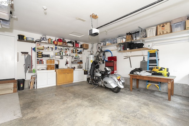 garage featuring a workshop area, a garage door opener, and gas water heater