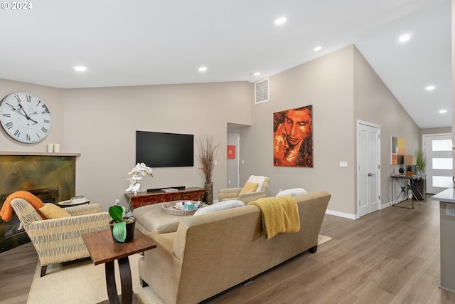 living room featuring high vaulted ceiling and hardwood / wood-style floors