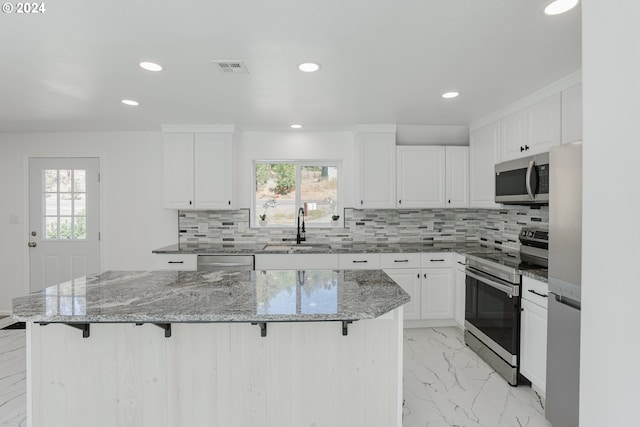 2840 Canyonville Riddle Rd, Riddle, OR 97469 - kitchen featuring a wealth of natural light, appliances with stainless steel finishes, marble finish floor, a sink, and a breakfast bar area