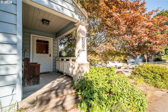 view of exterior entry featuring covered porch