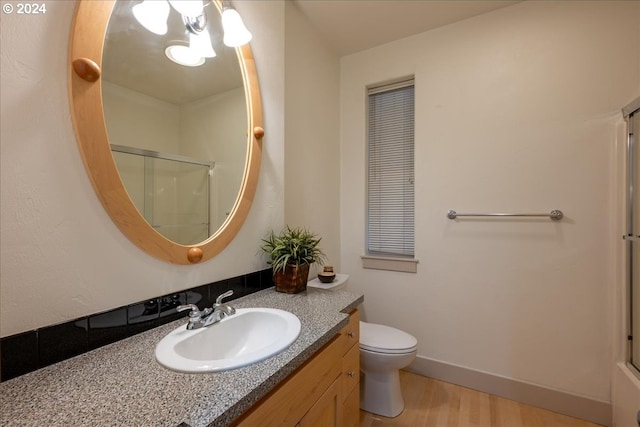 bathroom with vanity, wood-type flooring, an enclosed shower, and toilet