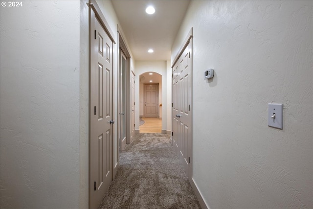 hallway featuring dark colored carpet