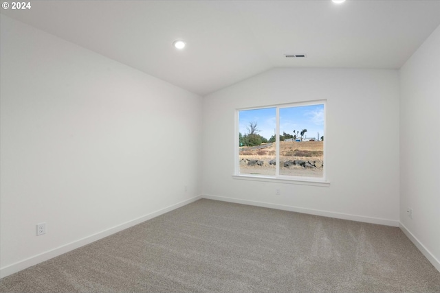 carpeted empty room with lofted ceiling