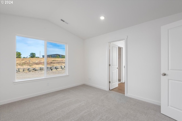 unfurnished bedroom featuring vaulted ceiling and carpet