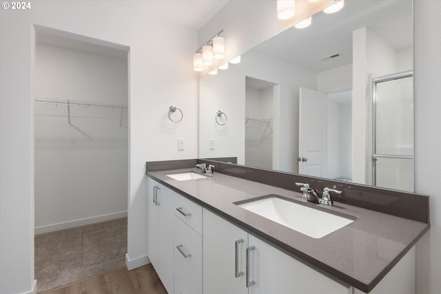 bathroom featuring vanity, a shower with shower door, and hardwood / wood-style floors