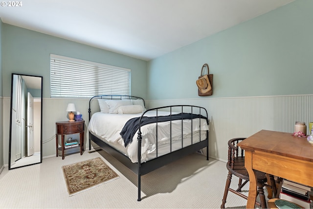 carpeted bedroom featuring wooden walls