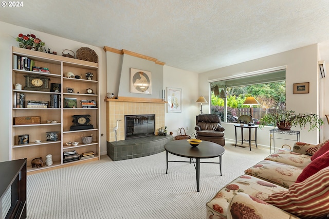 carpeted living room featuring a textured ceiling and a tiled fireplace