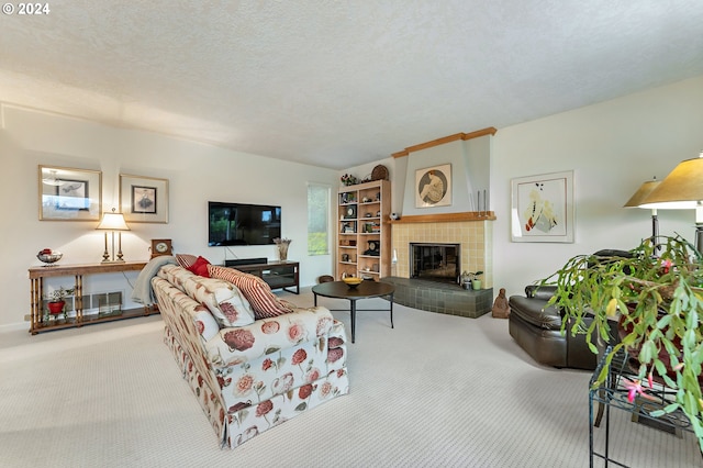 carpeted living room with a tiled fireplace and a textured ceiling