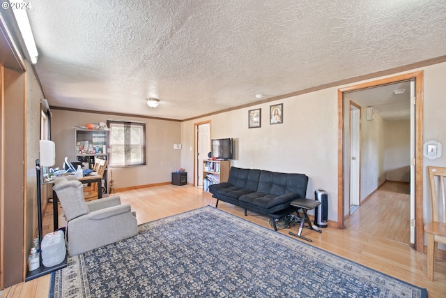 living room featuring wood-type flooring, a textured ceiling, and ornamental molding