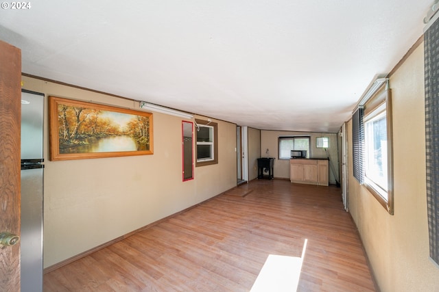 spare room with crown molding and light wood-type flooring