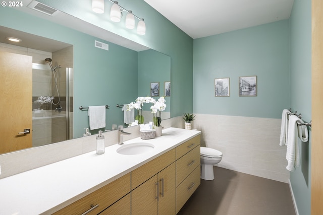 bathroom with toilet, an enclosed shower, and vanity