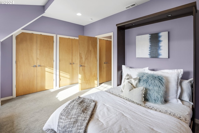 carpeted bedroom featuring multiple closets