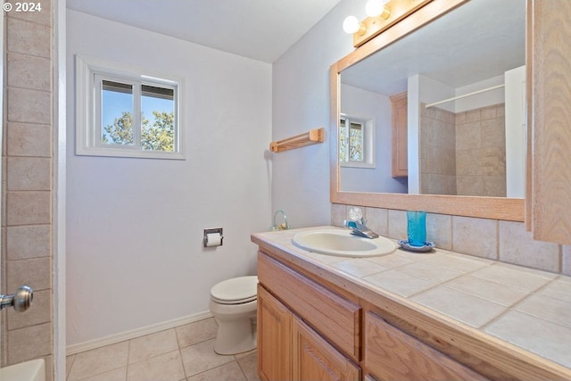 bathroom with tile patterned flooring, backsplash, vanity, a shower, and toilet