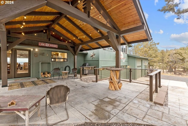 view of patio with exterior fireplace and a gazebo