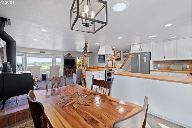 dining space with a wood stove and a notable chandelier