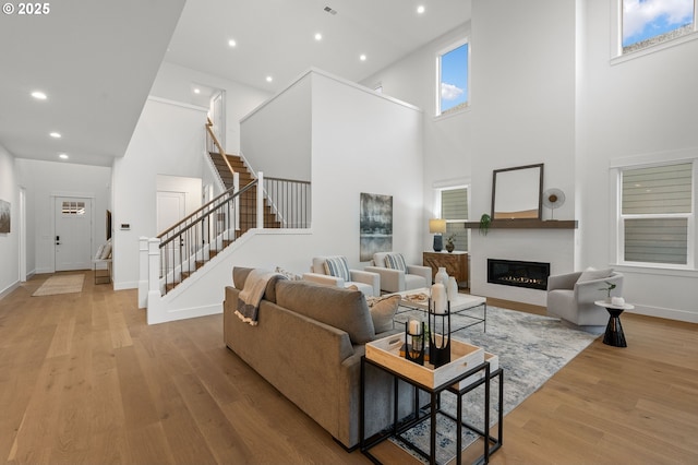 living room featuring a towering ceiling and light hardwood / wood-style floors