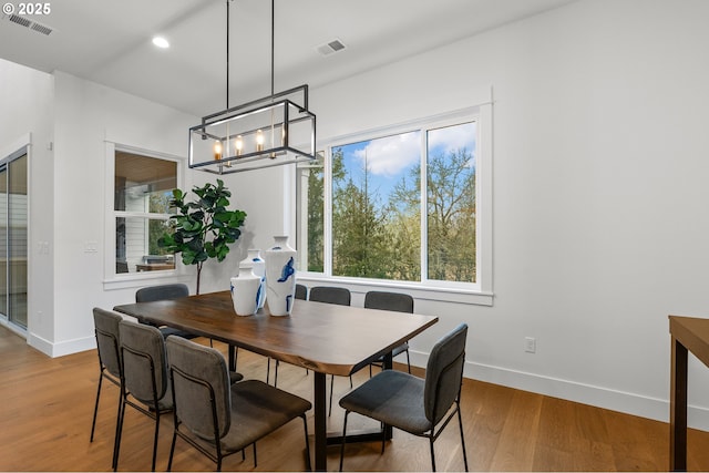 dining area with an inviting chandelier and wood-type flooring