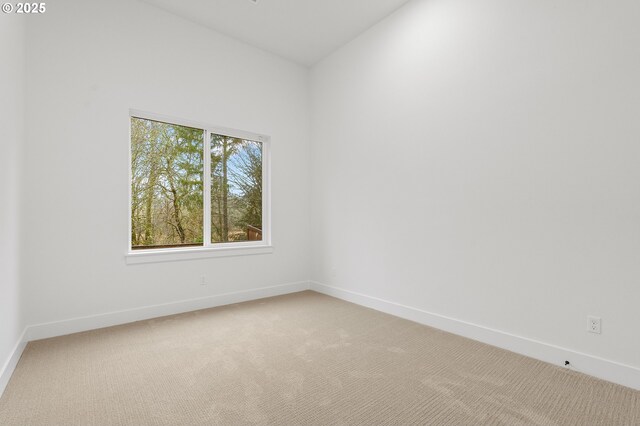 carpeted empty room featuring lofted ceiling