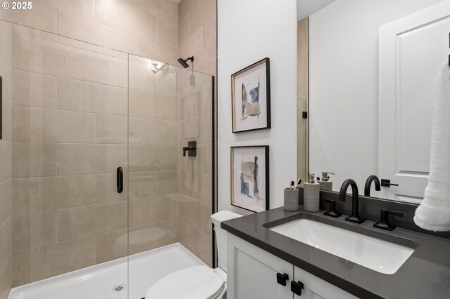 bathroom featuring an enclosed shower, vanity, and toilet