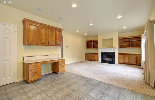 kitchen featuring a fireplace and light carpet