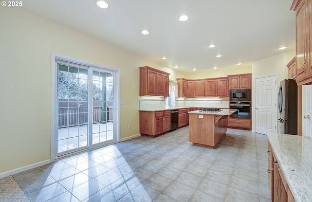 kitchen featuring light stone countertops, a kitchen breakfast bar, a center island, and stainless steel appliances