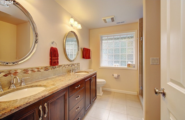 bathroom with tile patterned flooring, vanity, toilet, and walk in shower