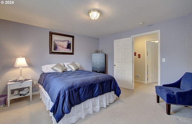 bedroom featuring light carpet and a textured ceiling