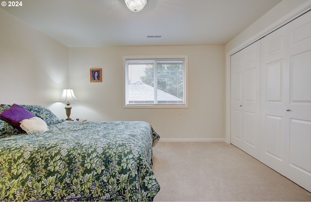 bedroom with light carpet and a closet