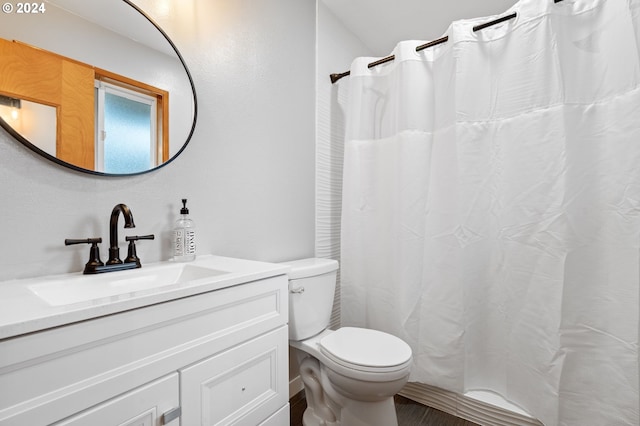 bathroom with vanity, curtained shower, and toilet