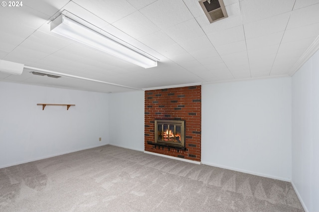 unfurnished living room with ornamental molding, a brick fireplace, and carpet flooring