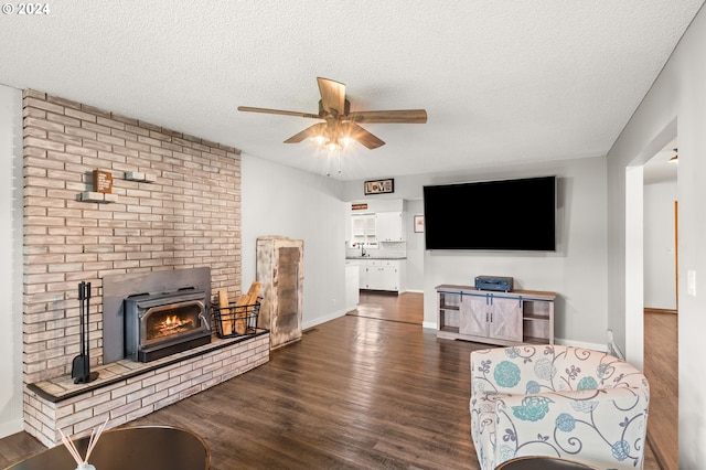 living room with dark wood-type flooring, a textured ceiling, and ceiling fan