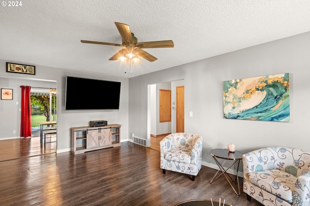 living room featuring dark hardwood / wood-style floors, a textured ceiling, and ceiling fan