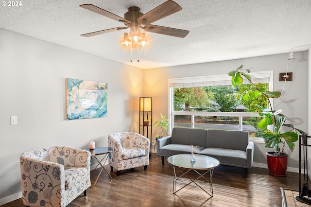 living area featuring ceiling fan, a textured ceiling, and dark hardwood / wood-style floors