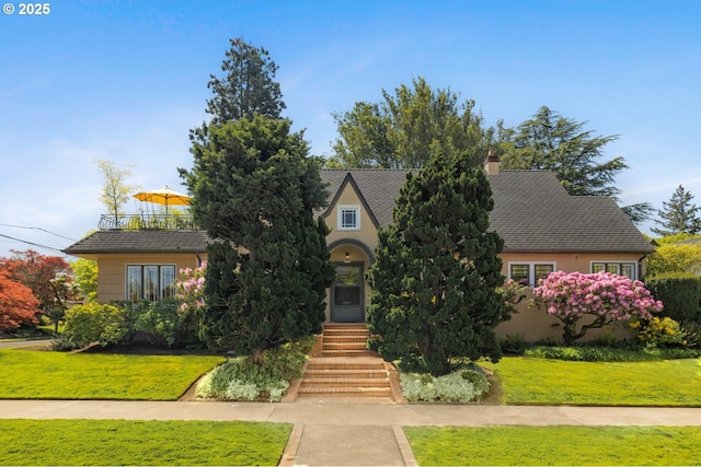 2130 NE Klickitat St, Portland, OR 97212 - view of front of house featuring a front lawn, stucco siding, a chimney, and a shingled roof