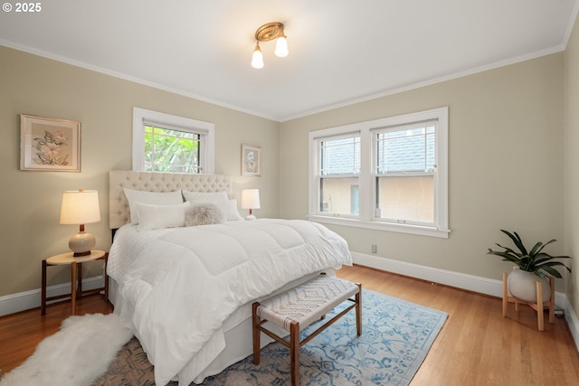 bedroom featuring wood finished floors, baseboards, and ornamental molding