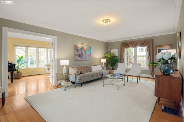 living room with plenty of natural light, visible vents, and light wood finished floors