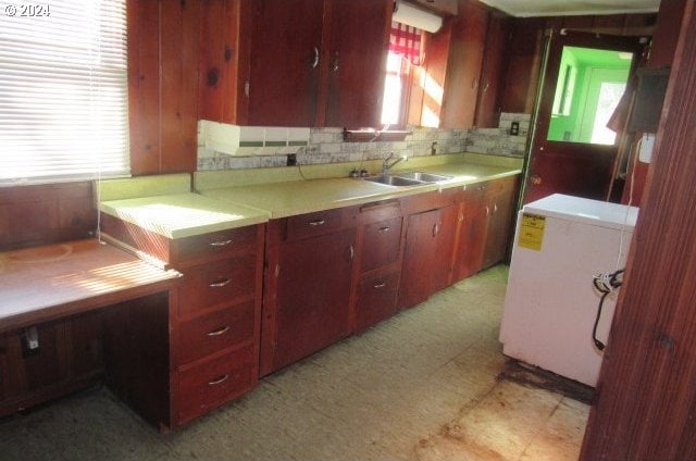 kitchen featuring washer / dryer, sink, and backsplash