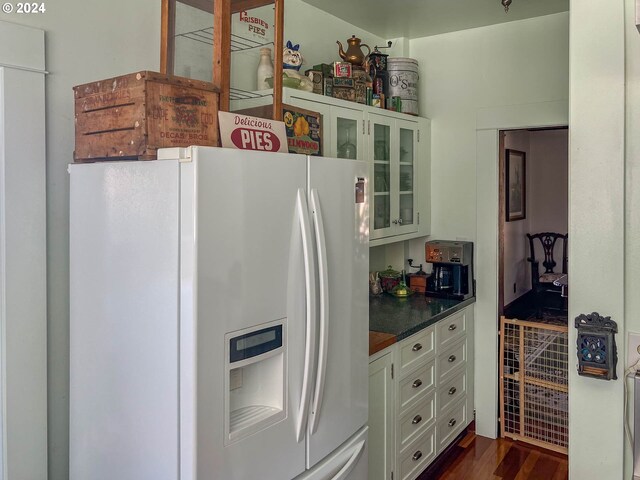 kitchen featuring white cabinetry, dark hardwood / wood-style flooring, and white fridge with ice dispenser